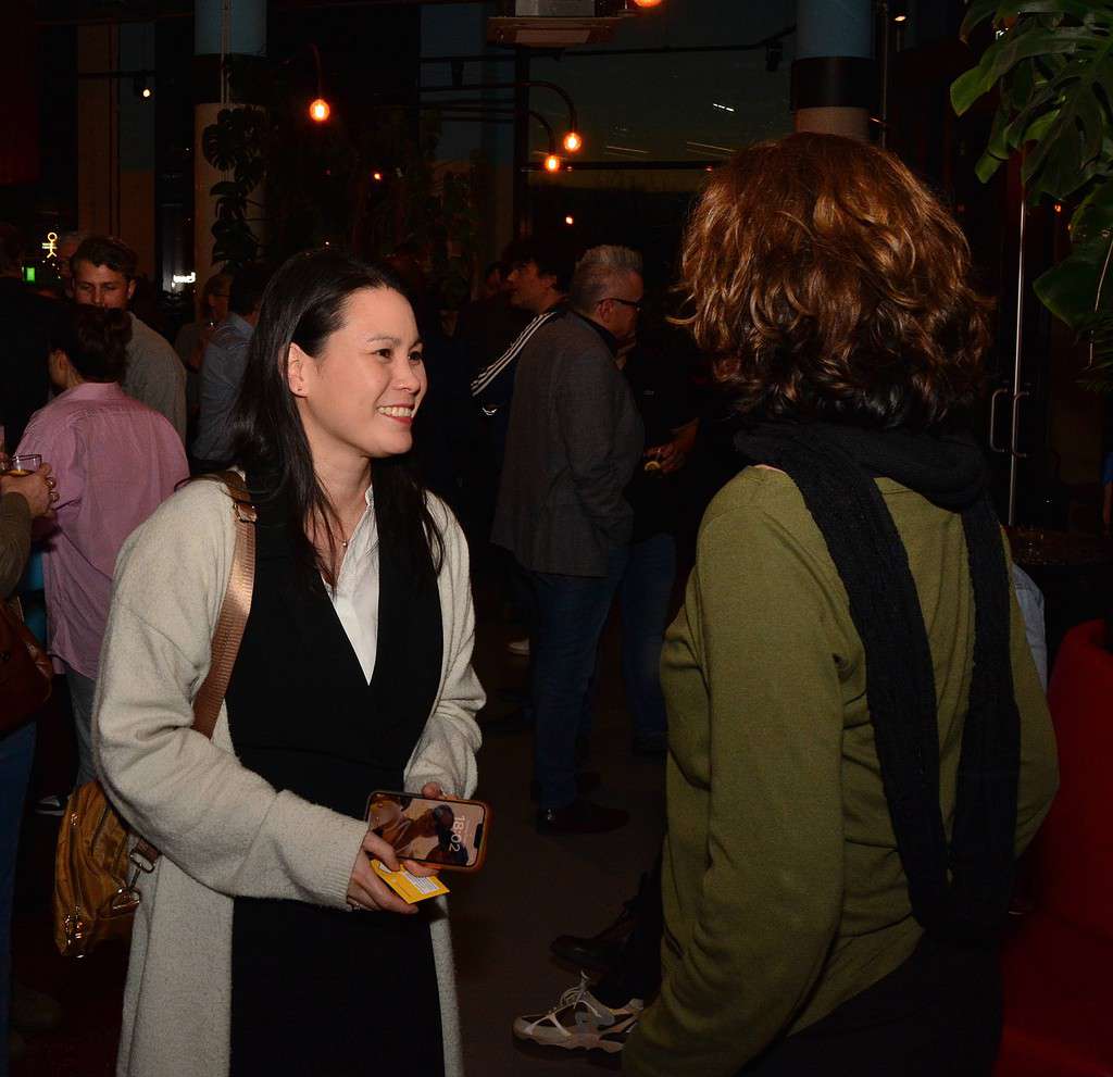 Bij The Social Hub gaat een vrouw in gesprek met een andere vrouw tijdens een bruisend feest.